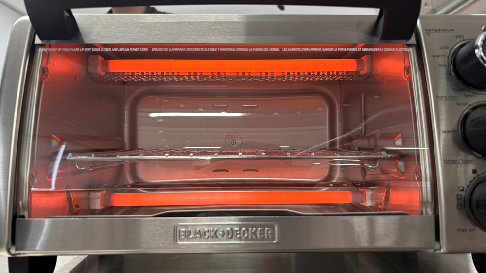 Quartz heating elements in the Black+Decker Natural Convection 4-Slice TO1756SB toaster oven, glowing as they radiate heat.