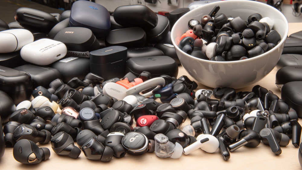 Image shows tens of true wireless earbuds in piles.