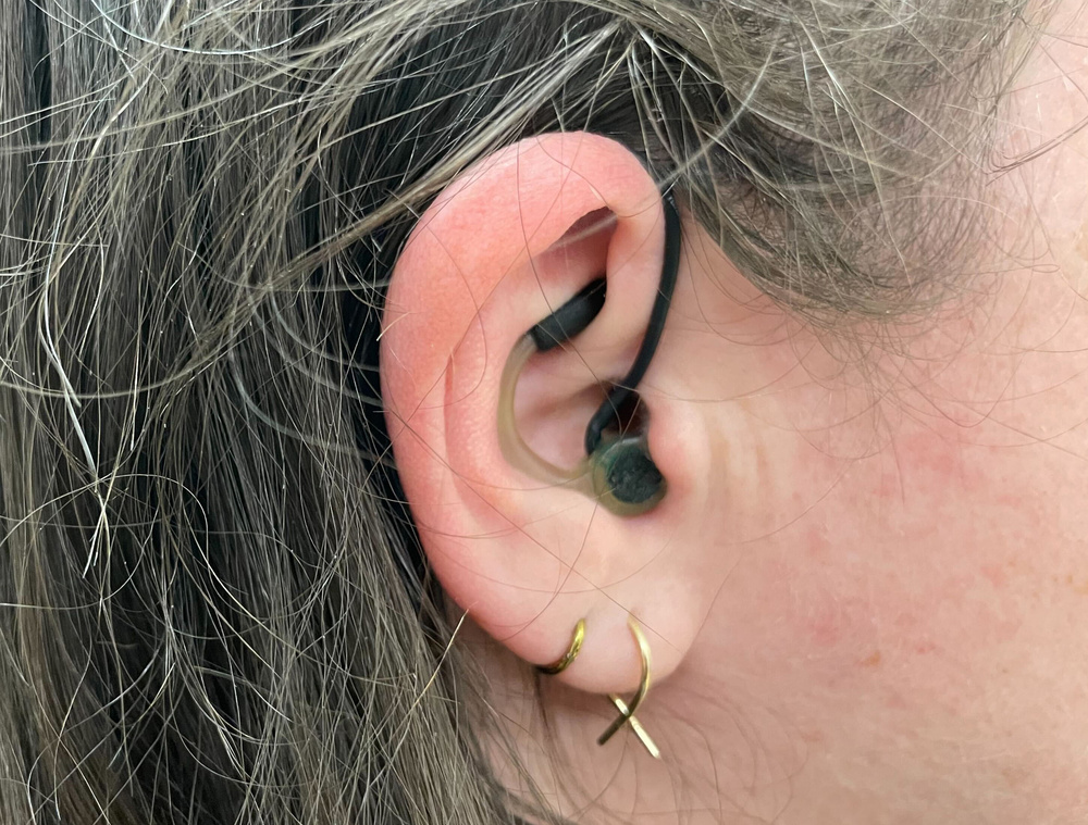 Close up image of an ear with a microphone placed inside of it.
